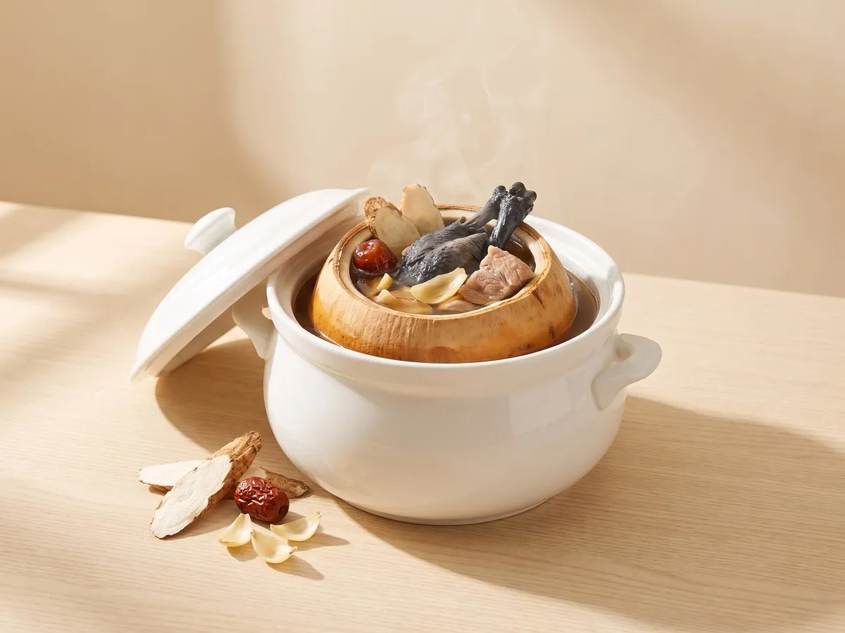 Double-boiled silkie chicken in whole king coconut
